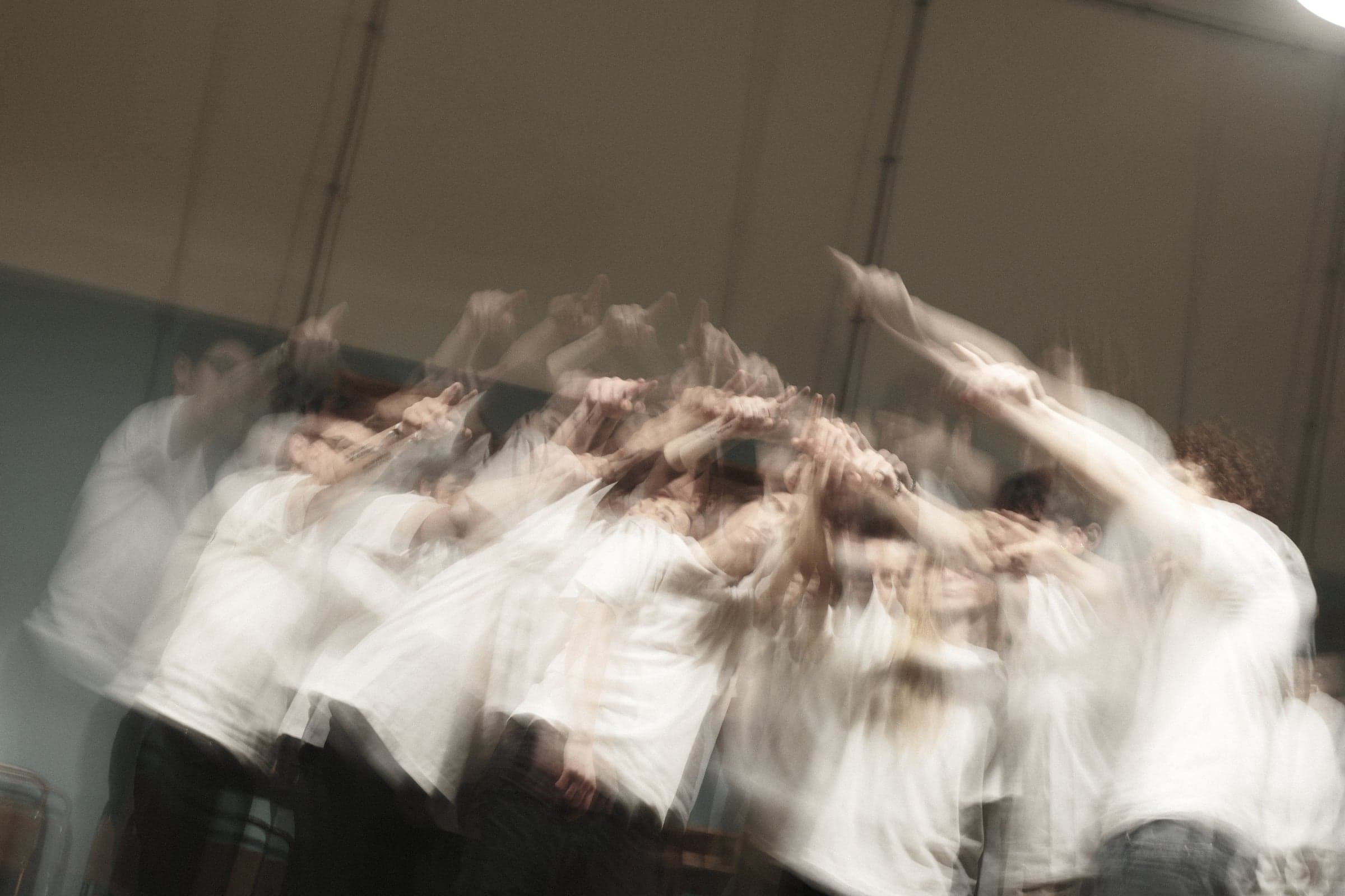 Performers in white moving together, blurred in motion